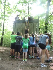 Zach scales the wall...with some help from team.